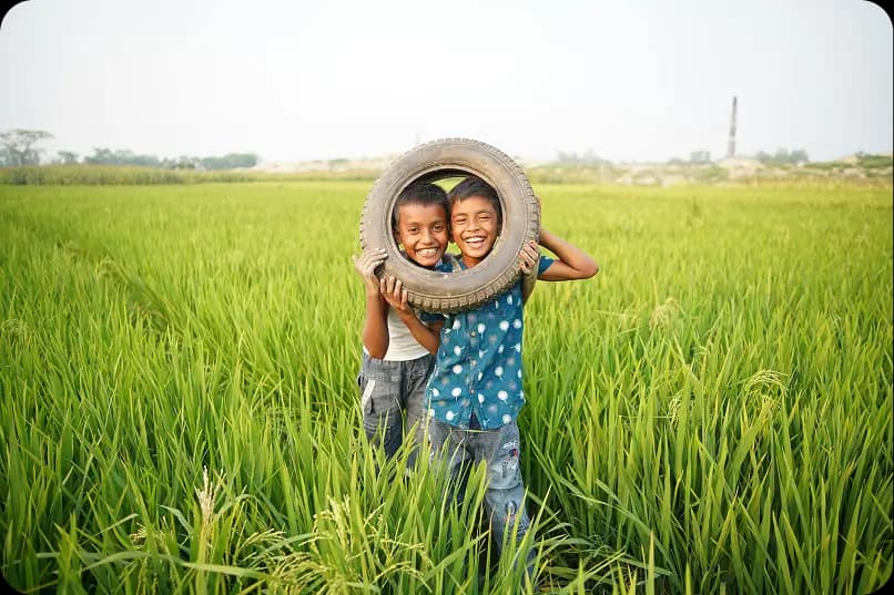 Children smiling in a green field